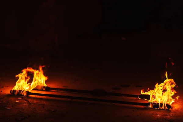 orange fire from an iron torch. Burning kerosene on a cane rag. burning staff on the stone floor. dangerous fire from flammable liquid at fire show