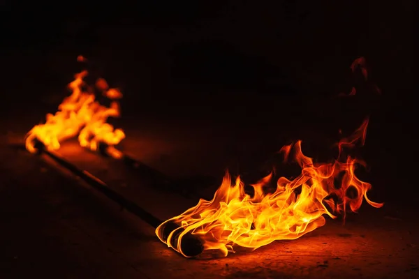 orange fire from an iron torch. Burning kerosene on a cane rag. burning staff on the stone floor. dangerous fire from flammable liquid at fire show