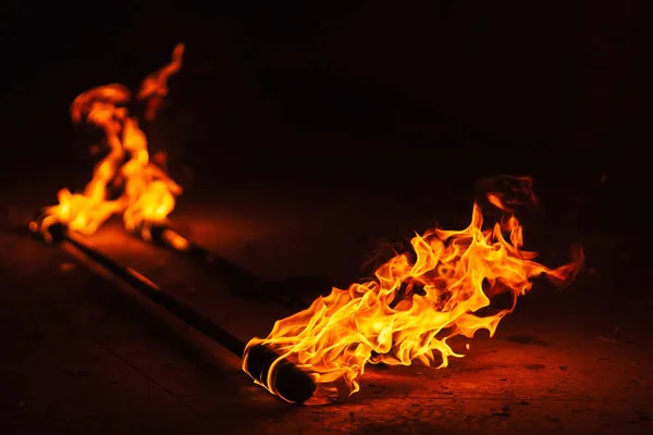 orange fire from an iron torch. Burning kerosene on a cane rag. burning staff on the stone floor. dangerous fire from flammable liquid at fire show