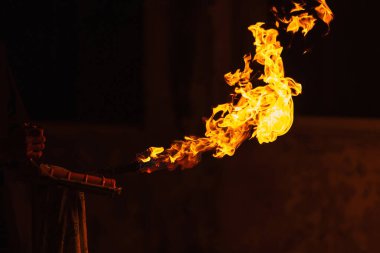 orange fire from a homemade flamethrower. Burning kerosene under pressure. a burning torch on the hand of a fire show worker. dangerous fire from flammable liquid at fire show