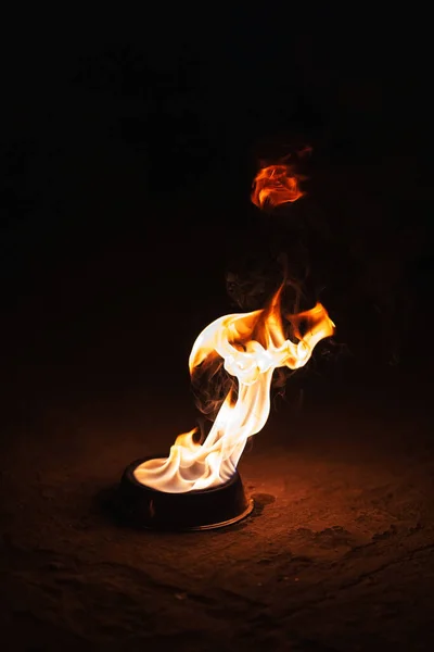 orange fire on a dark background. Burning kerosene in an iron plate. a burning torch for fire show workers. dangerous fire from flammable liquid