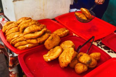fried dough in the canteen of Tashkent. Deep-fried pies with potatoes at the Uzbek bazaar. national fast food of uzbekistan butter dough with stuffing