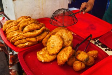 fried dough in the canteen of Tashkent. Deep-fried pies with potatoes at the Uzbek bazaar. national fast food of uzbekistan butter dough with stuffing