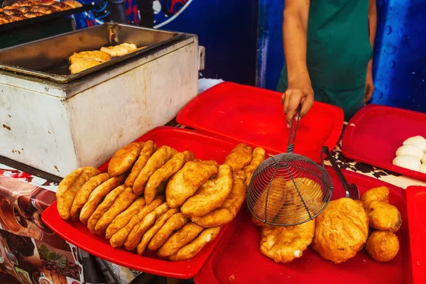 fried dough in the canteen of Tashkent. Deep-fried pies with potatoes at the Uzbek bazaar. national fast food of uzbekistan butter dough with stuffing