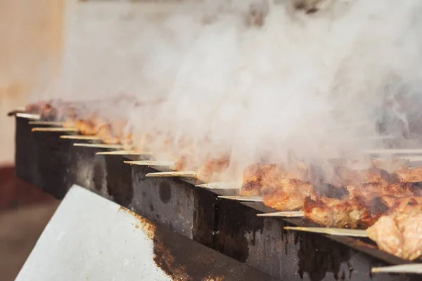 grilled meat on coals in a cafe in uzbekistan. barbecue on the grill in a tourist place. frying sheep meat on wood in tashkent