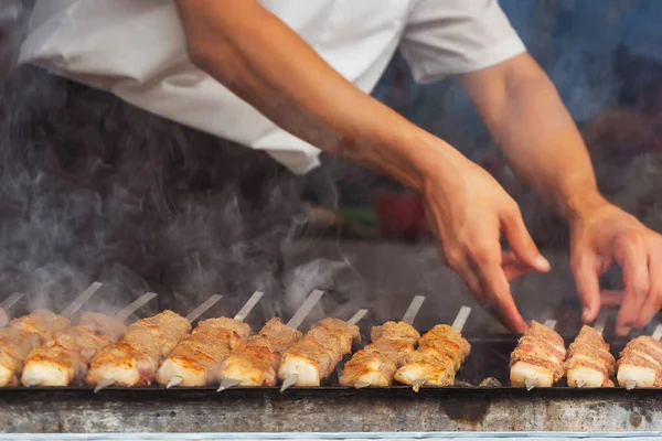 grilled meat on coals in a cafe in uzbekistan. barbecue on the grill in a tourist place. frying sheep meat on wood in tashkent