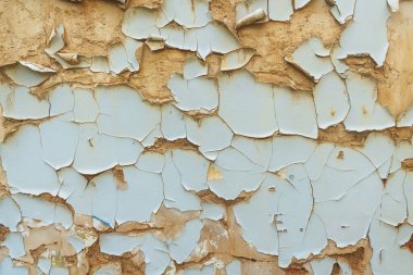 the texture of peeling paint in the house due to dampness. fallen off pieces of paint in a house without a roof