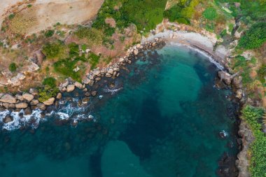 rocky coast of turkish cyprus. clean water on the island of cyprus. beautiful but problematic rocky beaches in cyprus. drone photo of blue sea and brown rocky beach