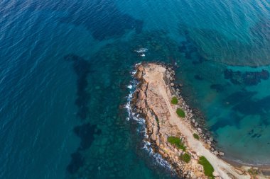 rocky coast of turkish cyprus. clean water on the island of cyprus. beautiful but problematic rocky beaches in cyprus. drone photo of blue sea and brown rocky beach