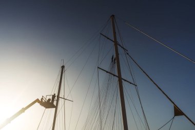 welding works of the mast on the ship. repair of sail holders on a yacht using a hydraulic platform. work of a welder at height