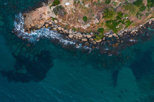 rocky coast of turkish cyprus. clean water on the island of cyprus. beautiful but problematic rocky beaches in cyprus. drone photo of blue sea and brown rocky beach