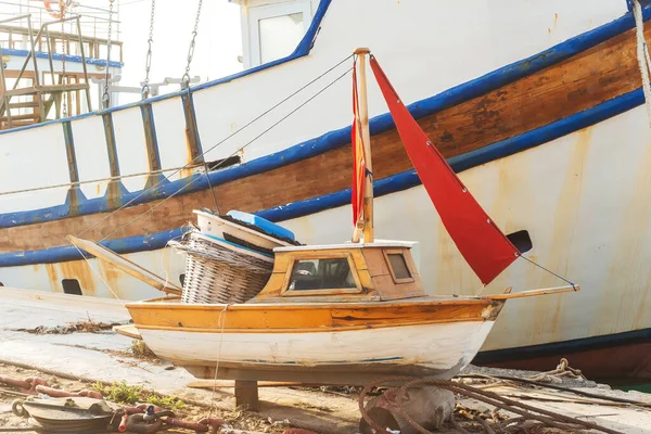 small children\'s wooden boat on the pier. toy exhibition boat for tourists in cyprus. repair depot for boats of different sizes