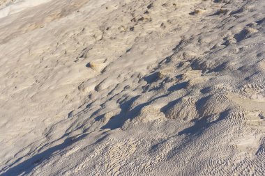 texture of white stones in pamukkale. white layers of calcium in Turkish pamukkale. white mounds of minerals from large amounts of evaporated water.