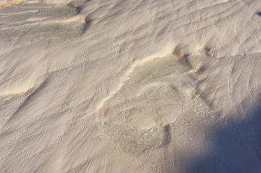 texture of white stones in pamukkale. white layers of calcium in Turkish pamukkale. white mounds of minerals from large amounts of evaporated water.