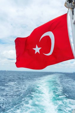 Mavi denizin arka planında kırmızı hindi bayrağı var. Bir yıldızlı bayrak ve bir yolcu gemisinde hilal..