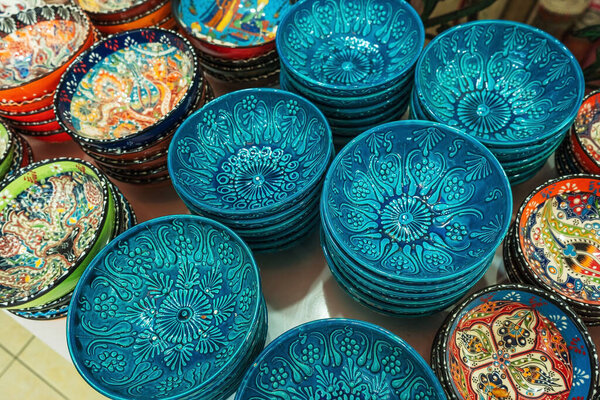 national turkish glass souvenirs. handmade souvenir for tourists in turkey. plates for dried fruits in istanbul bazaar. saucers hand painted with enamel
