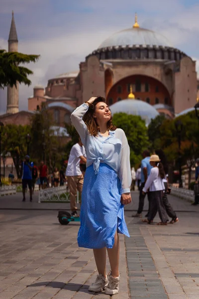 モスクを背景に青いスカートに身を包んだヨーロッパの少女 イスタンブールのハギア ソフィアを背景にした少女の写真撮影会です 観光スポットを背景にイスタンブールの観光客の写真 — ストック写真