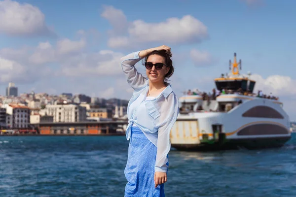 a girl in a blue skirt in istanbul on the background of the sea. Russian happy girl in light clothes