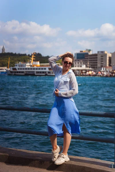 a girl in a blue skirt in istanbul on the background of the sea. Russian happy girl in light clothes