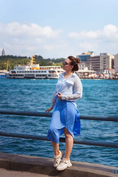 a girl in a blue skirt in istanbul on the background of the sea. Russian happy girl in light clothes