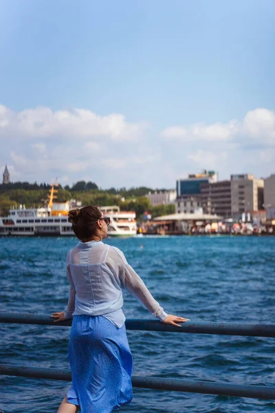 a girl in a blue skirt in istanbul on the background of the sea. Russian happy girl in light clothes