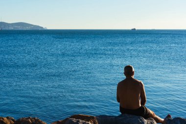 Bir adam mermer denizin kıyısında dinleniyor. İstanbul Denizi 'ne banyo yapmaya bir adam geldi. Açık denizlerde yelken açmaya hazırlanıyorlar.