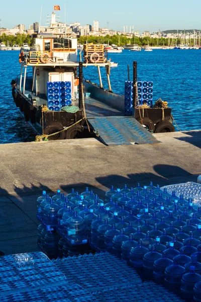 delivery of drinking water to the island in istanbul. replenishment of provisions and water by sea. storage of clean bottled water on the pier. waiting for food and water to be loaded onto the ship