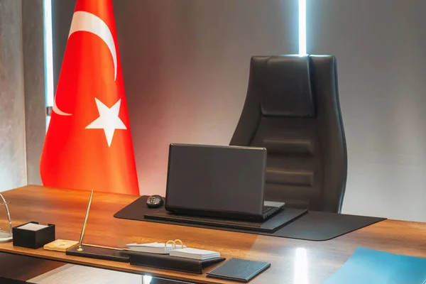 director\'s office in a Turkish company. black laptop on wooden table and black leather chair