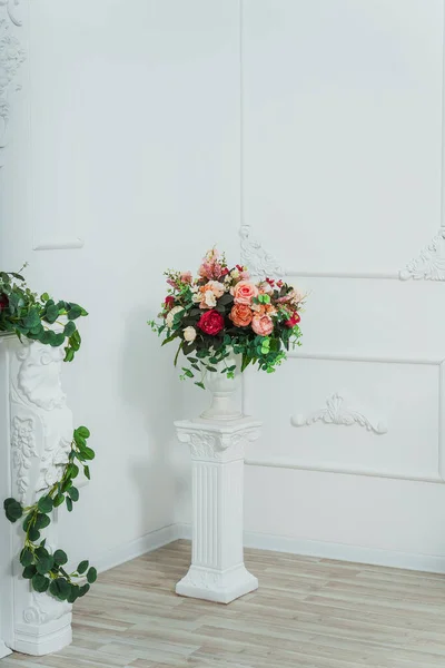 white column in a classic room. light pedestal decorated with flowers. classic interior in the living room for a wedding photo shoot