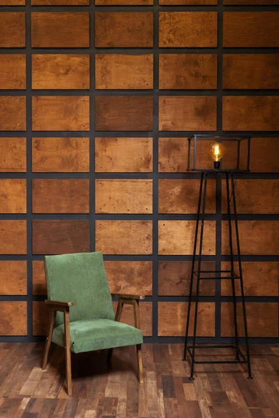 stock image wooden armchair on the background of a wall with wooden inserts. classic photo zone with a chair for a wedding photo shoot. brown room with green armchair