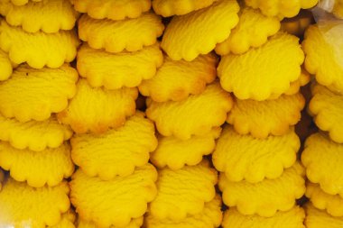 Sarı yuvarlak kurabiyeler arka planda bir kutuda. Beyaz arka planda, konteynırın içinde ucuz kurabiyeler. Katalog için şekerleme fotoğrafı