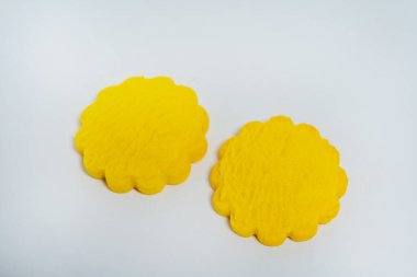 Hafif arka planda sarı yuvarlak kurabiyeler. Beyaz arka planda satılık ucuz kurabiyeler. Katalog için şekerleme fotoğrafı