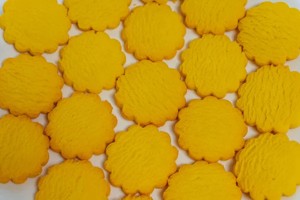 yellow round cookies on a light background. Crumbly cheap cookies for sale on a white background. photo of confectionery for the catalog