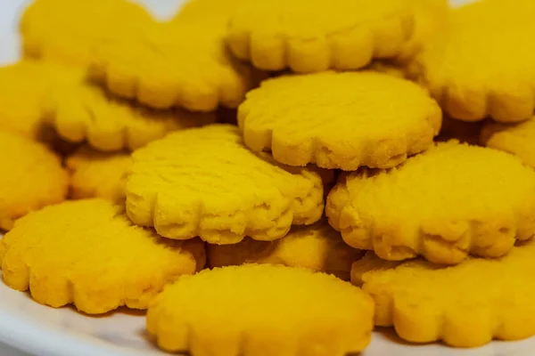 薄い背景に黄色い丸クッキー 白い背景に皿の上にザッと安いクッキー カタログのお菓子の写真 — ストック写真