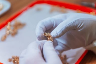 İşletmedeki altın ürünlerinin kalite kontrolü. Markete gönderilmek üzere altın yüzük ve küpe hazırlanıyor. Fabrikada değerli taşları olan altın mücevher üretimi.