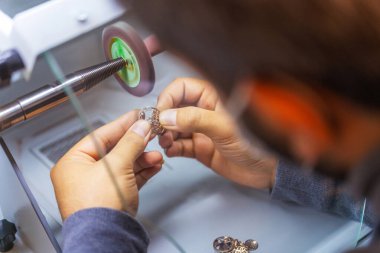 Özel ekipmanlara altın mücevher cilalamak. Altın yüzüklü bir kuyumcunun işi. Fabrikada altın boyası üretimi. Mücevher parlatıcılığı.