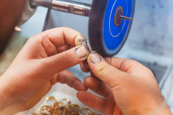 polishing gold jewelry on special equipment. work of a jeweler with gold rings. production of gold dyes at the factory. jewelry polishing at the enterprise