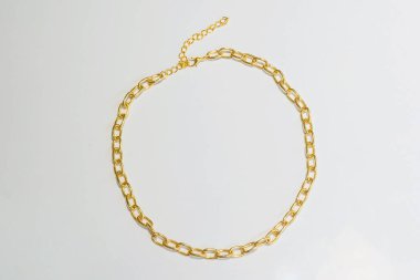 Beyaz arka planda altın bir çağrı. Hafif arka planda altın kaplama bijouterie zinciri. Katalog için bojouterie fotoğrafları