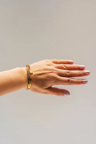 Mão Mulher Com Uma Pulseira Ouro Fundo Branco Escova Uma — Fotografia de Stock