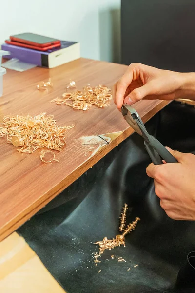 biting off marriage on gold items. work with wire cutters for gold and silver at the production site. production of gold jewelry with precious stones at the factory.
