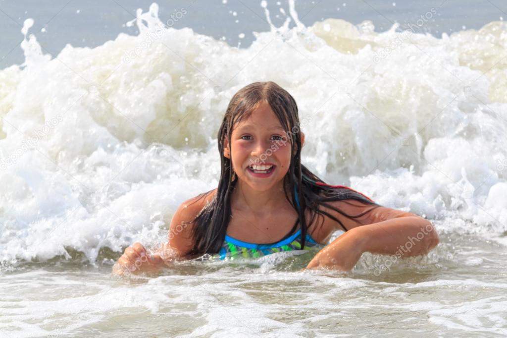 Young girl playing in ocean waves.