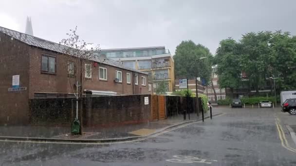 Медленное движение сильного дождя в жилом комплексе в Бермондси, Лондон, Великобритания — стоковое видео
