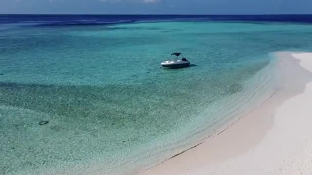 透明なターコイズブルーの海と熱帯のエキゾチックな島の湾に固定されたボートの空中ドローンビデオ — ストック動画