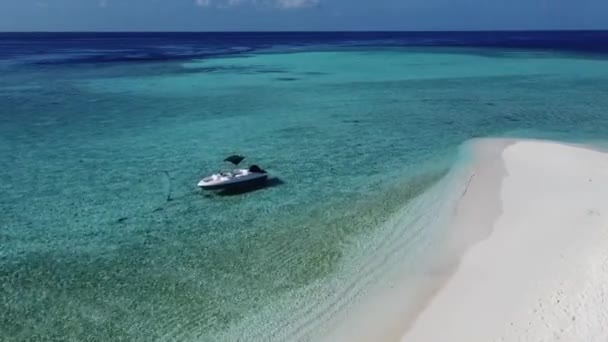 透明なターコイズブルーの海と熱帯のエキゾチックな島の湾に固定されたボートの空中ドローンビデオ — ストック動画