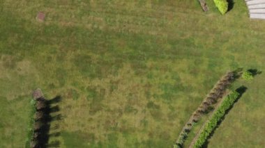 Aerial top down view from the drone on the narrow passageway leading to a small chapel. Chapel located in a big green open area of fields near Rosary Manor, Mill Hill, North West London, London, UK.