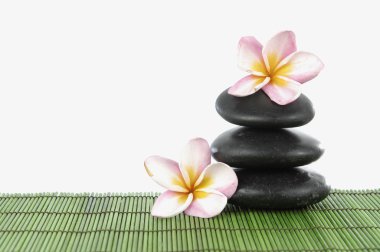 Frangipani çiçek ve mat yığılmış taşlar