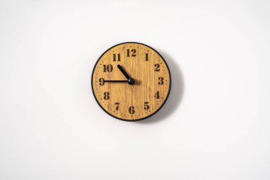 Beyaz zemin üzerinde beyaz kadranlı ahşap ofis duvar saati. Beyaz arkaplanda duvar saati, en üst görünüm.