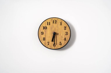 Beyaz zemin üzerinde beyaz kadranlı ahşap ofis duvar saati. Beyaz arkaplanda duvar saati, en üst görünüm.