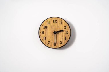 Beyaz zemin üzerinde beyaz kadranlı ahşap ofis duvar saati. Beyaz arkaplanda duvar saati, en üst görünüm.