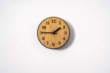 Beyaz zemin üzerinde beyaz kadranlı ahşap ofis duvar saati. Beyaz arkaplanda duvar saati, en üst görünüm.
